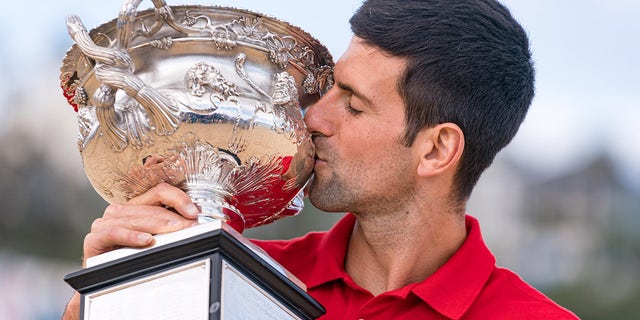 Novak Djokovic of Serbia kisses the Norman Brookes Challenge Cup after winning the 2021 Australian Open Men's Final, at Brighton Beach on Feb. 22, 2021, in Melbourne, Australia.
