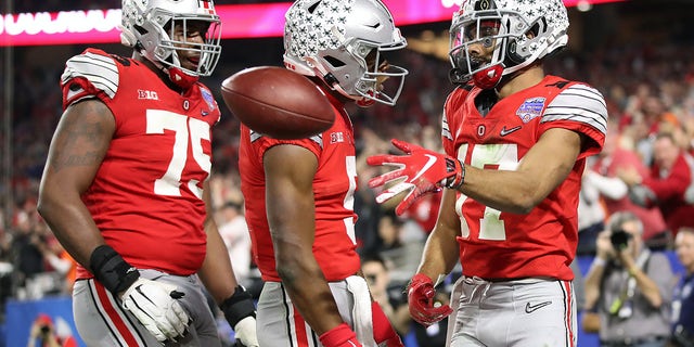 Chris Olave #17 of the Ohio State Buckeyes is congratulated by his teammates after his touchdown reception against the Clemson Tigers in the second half during the College Football Playoff Semifinal at the PlayStation Fiesta Bowl at State Farm Stadium on December 28, 2019 in Glendale, Arizona.