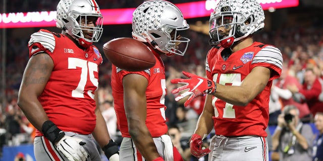 Chris Olave #17 of the Ohio State Buckeyes is congratulated by his teammates after his touchdown reception against the Clemson Tigers in the second half during the College Football Playoff Semifinal at the PlayStation Fiesta Bowl at State Farm Stadium on December 28, 2019 in Glendale, Arizona.