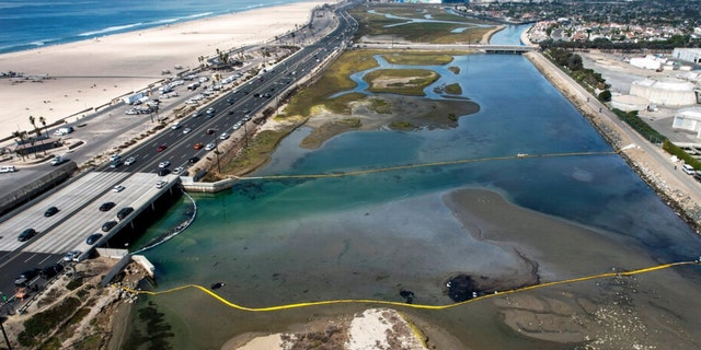 An aerial photo shows floating barriers known as booms in an attempt to stop a new incursion into the Talbert Wetlands Marsh after an oil spill in Huntington Beach, Calif., In Huntington Beach, Calif. On Monday, October 4 2021.