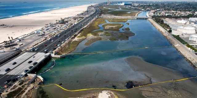 An aerial photo shows floating barriers known as booms to try to stop further incursion into the Wetlands Talbert Marsh after an oil spill in Huntington Beach, Calif., on Huntington Beach, Calif., on Monday, Oct. 4, 2021. A major oil spill off the coast of Southern California fouled popular beaches and killed wildlife while crews scrambled Sunday, to contain the crude before it spread further into protected wetlands. (AP Photo/Ringo H.W. Chiu)