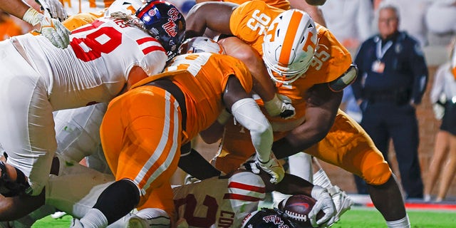 Mississippi running back Snoop Conner (24) scores a touchdown as he's hit by Tennessee defensive lineman Da'Jon Terry (95) and defensive lineman Ja'Quain Blakely (48) during the first half of an NCAA college football game Saturday, Oct. 16, 2021, in Knoxville.