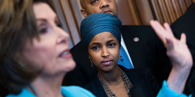 Rep. Ilhan Omar, D-Minn., right, and Speaker of the House Nancy Pelosi, D-Calif., attend a bill enrollment ceremony for the Juneteenth National Independence Day Act in the Capitol on Thursday, June 17, 2021.
