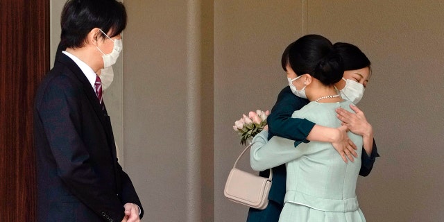 Japan's Princess Mako, right, hugs her sister Princess Kako, watched by her parents Crown Prince Akishino and Crown Princess Kiko, before leaving her home in Akasaka Estate in Tokyo on Tuesday.