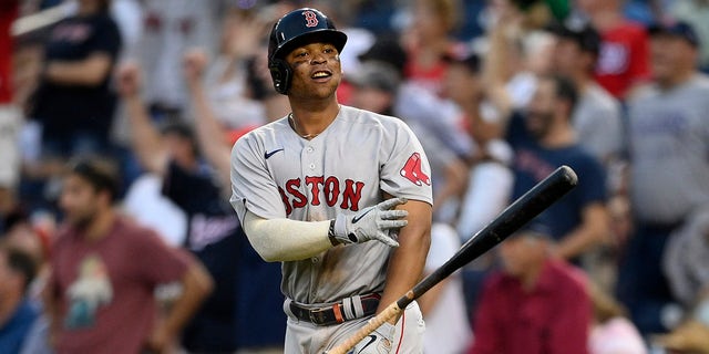 Boston Red Sox' Rafael Devers tosses his bat and celebrates his two-run home run during the ninth inning of a game against the Washington Nationals, 星期日, 十月. 3, 2021, 在华盛顿. The Red Sox won 7-5.