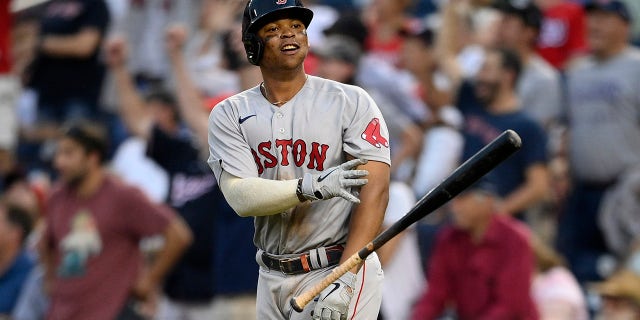 Boston Red Sox' Rafael Devers tosses his bat and celebrates his two-run home run during the ninth inning of a game against the Washington Nationals, 星期日, 十月. 3, 2021, 在华盛顿. The Red Sox won 7-5.