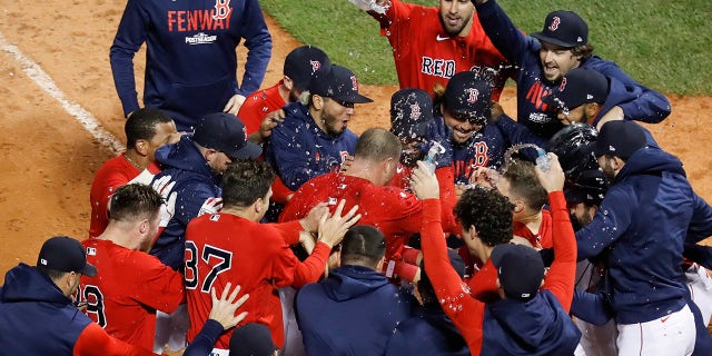 Boston Red Sox Christian Vazquez is mobbed by teammates after hitting a two-run home run in the thirteenth inning against the Tampa Bay Rays in Game 3 of an American League Baseball Division Series, the Sunday, October 10, 2021, in Boston.  Boston won 6-4.