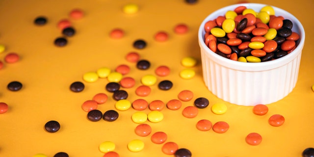 Reese’s Pieces were invented and released in the 1970s by Hershey. The hard-shell candies have a chocolate-peanut butter center.
