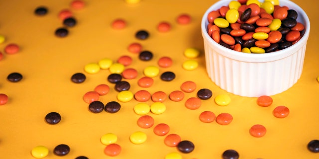 Reese’s Pieces were invented and released in the 1970s by Hershey. The hard-shell candies have a chocolate-peanut butter center.