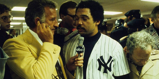 Reggie Jackson #44 of the New York Yankees is interviewed by Bob Uecker in the locker after the Yankees won the World Series against the Los Angeles Dodgers on Oct. 18, 1977 at Yankee Stadium in Bronx, New York.