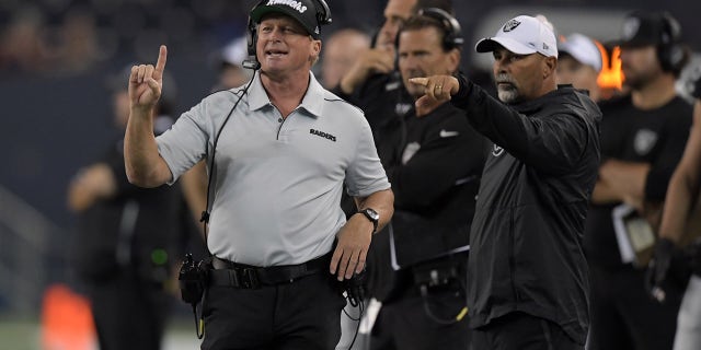 O técnico do Oakland Raiders, John Gruden (à esquerda), e o coordenador de times especiais Rich Bisachia assistem da lateral do campo contra o Green Bay Packers no segundo tempo no Investors Group Field, em 22 de agosto de 2019, em Winnipeg, Manitoba, Canadá.  Os invasores derrotaram Hazm, 22-21.