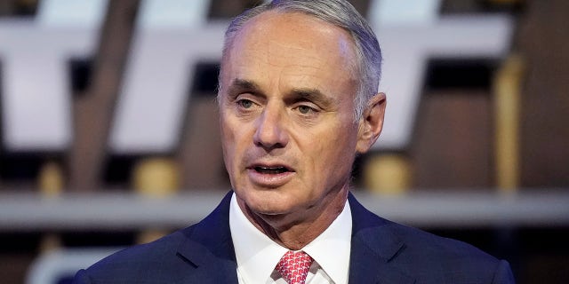 FILE - In this July 11, 2021, file photo, Major League Baseball Commissioner Rob Manfred kicks off the first round of the 2021 MLB baseball draft in Denver. Baseball’s ninth work stoppage and first in 26 years appears almost certain to start Dec. 2, 2021, freezing the free-agent market and threatening the start of spring training in February.