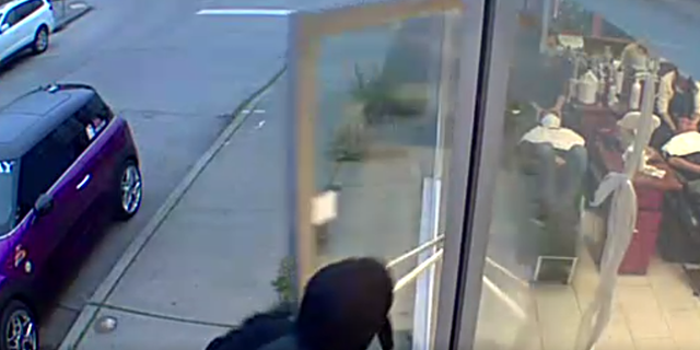 A street view of the robbers entering the hair salon. 
