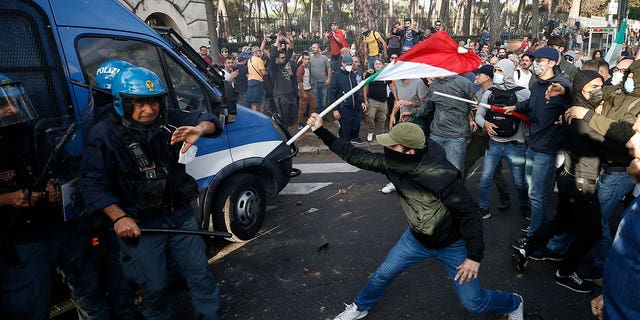 Zusammenstöße zwischen Polizei und Demonstranten während einer Protestaktion in Rom, Samstag, 9. Oktober 2021. Tausende Demonstranten protestierten am Samstag in Rom gegen die COVID-19-Gesundheitskarte, die italienische wie öffentliche und private Arbeitnehmer vorlegen müssen, um ab dem 15. Oktober auf ihre Arbeitsplätze zuzugreifen per Regierungserlass.