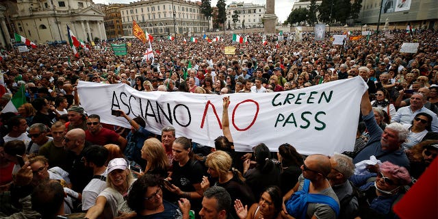 Menschen versammeln sich während einer Protestaktion in Rom, Samstag, 9. Oktober 2021, auf der Piazza del Popolo. Tausende Demonstranten protestierten am Samstag in Rom gegen die COVID-19-Gesundheitskarte, die sowohl öffentliche als auch private italienische Arbeitnehmer vor sich auslegen müssen. Ankunft an ihrem Arbeitsplatz ab dem 15. Oktober per Regierungserlass.
