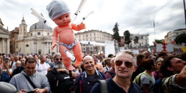 Un muñeco con jeringas es mostrado por un manifestante durante una manifestación, en Roma, el sábado 9 de octubre de 2021. Miles de manifestantes se manifestaron en Roma el sábado contra el pase de salud COVID-19 que deben colocar los trabajadores italianos, sectores público y privado para acceder a sus lugares de trabajo a partir del 15 de octubre en virtud de un decreto del gobierno. 