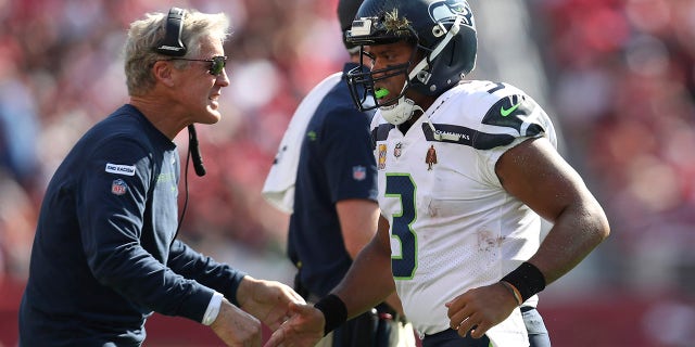 Seattle Seahawks quarterback Russell Wilson is congratulated by head coach Pete Carroll after scoring against the San Francisco 49ers in Santa Clara, California, on Oct. 3, 2021.