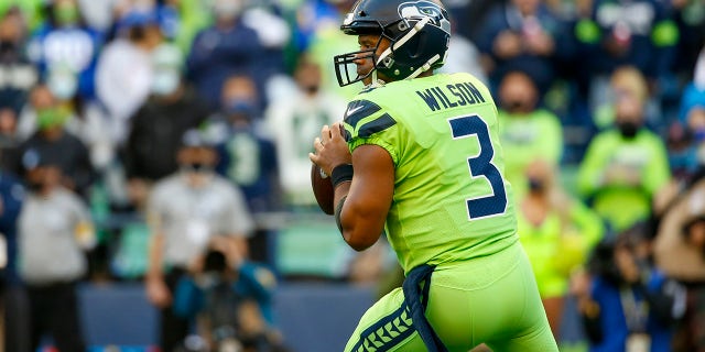 O quarterback do Seattle Seahawks, Russell Wilson, parece passar na frente do Los Angeles Rams durante o primeiro quarto no Lumen Field.