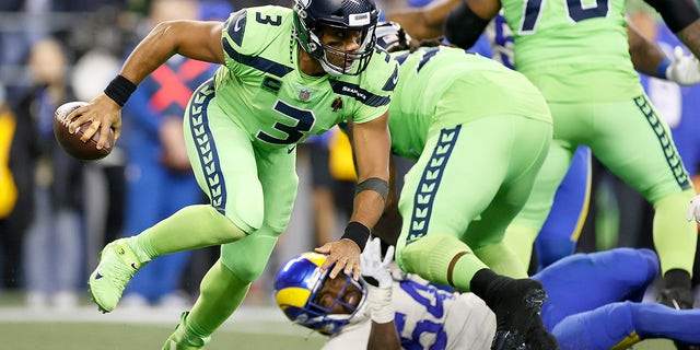 Seattle Seahawks quarterback Russell Wilson struggles with the ball against the Los Angeles Rams in the second half at Lumen Field on October 7, 2021, in Seattle, Washington.