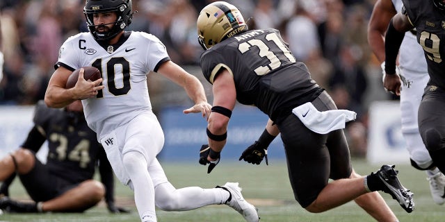 Wake Forest quarterback Sam Hartman (10) runs past Army linebacker Karsonne Winters (31) during the first half of an NCAA college football game Saturday, Oct. 23, 2021, in West Point, N.Y.