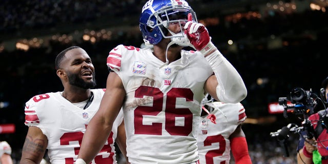 New York Giants running back Saquon Barkley (26) celebrates his touchdown in overtime to defeat the New Orleans Saints in an NFL football game in New Orleans, Sunday, Oct. 3, 2021. The Giants won 27-21