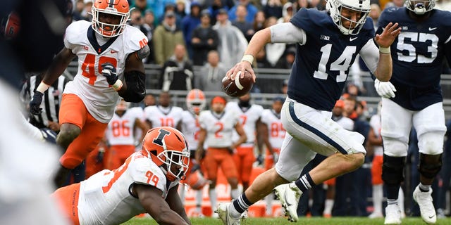 Penn State quarterback Sean Clifford (14) scrambles away from Illinois linebacker Owen Carney Jr. (99) in the first overtime of an NCAA college football game in State College, Pa., Saturday, Oct. 23, 2021. Illinois defeated Penn State 20-18 in the ninth overtime.