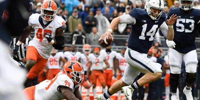 Penn State quarterback Sean Clifford (14) scrambles away from Illinois linebacker Owen Carney Jr. (99) in the first overtime of an NCAA college football game in State College, Pa., Saturday, Oct. 23, 2021. Illinois defeated Penn State 20-18 in the ninth overtime.