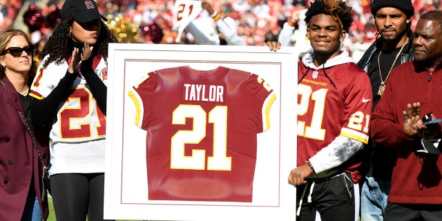 Family and friends of Sean Taylor stand during the retirement ceremony of Taylor's jersey at FedExField on October 17, 2021 in Landover, Maryland.