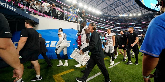 Players for the Las Vegas Raiders leave the field due to a weather delay shortly before the scheduled start an NFL football game against the Los Angeles Chargers, Monday, Oct. 4, 2021, in Inglewood, Calif.