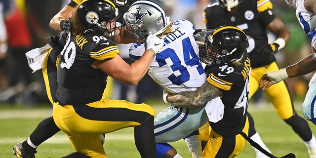 Pittsburgh Steelers defensive tackle Henry Mondeaux (99) and defensive end Cassius Marsh (49) tackle Dallas Cowboys running back Rico Dowdle (34) during the first half at Tom Benson Hall of Fame Stadium.