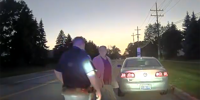An officer pulling over a man for speeding.