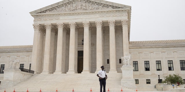 A police officer patrols in front of of the U.S. Supreme Court in Washington on Oct. 12, 2021.