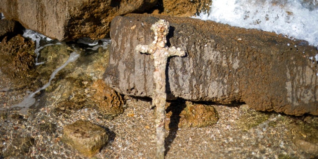 A meter-long (yard-long) sword, that experts say dates back to the Crusaders is on display in Mediterranean seaport of Cesarea, Israel, Tuesday, Oct. 19, 2021. 