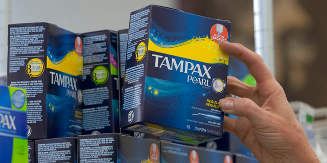 FILE: A worker restocks tampons at a supermarket. 