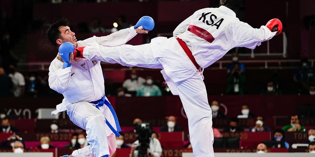 Sajad Ganjzadeh (L) of Team Iran gets injured as he competes against his Saudi opponent in last year's Olympic Games in Japan. According to reports, Gen. Qassem Soleimani, the late head of the IRGC’s Quds Force, was described as being very close to the karate team.