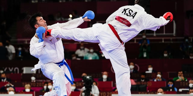 Sajad Ganjzadeh (L) of Team Iran gets injured as he competes against his Saudi opponent in last year's Olympic Games in Japan. According to reports, Gen. Qassem Soleimani, the late head of the IRGC’s Quds Force, was described as being very close to the karate team.