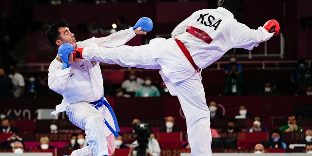 Sajad Ganjzadeh (L) of Team Iran gets injured as he competes against his Saudi opponent in last year's Olympic Games in Japan. According to reports, Gen. Qassem Soleimani, the late head of the IRGC’s Quds Force, was described as being very close to the karate team.