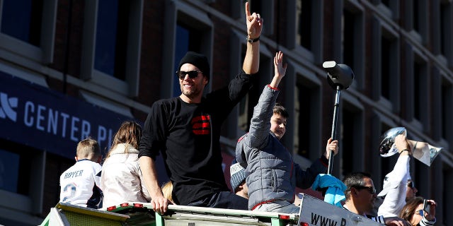 Tom Brady of the New England Patriots and his son Jack celebrate on Cambridge Street during the New England Patriots Victory Parade on Feb. 5, 2019, in Boston, Massachusetts.