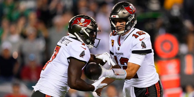 Tampa Bay Buccaneers quarterback Tom Brady (12) hands the ball off to Tampa Bay Buccaneers running back Leonard Fournette (7) during the first half of an NFL football game against the Philadelphia Eagles, Thursday, Oct. 14, 2021, in Philadelphia.