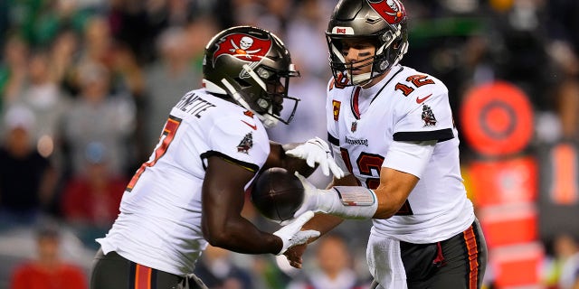 Durante la primera mitad del juego de fútbol americano de la NFL contra los Philadelphia Eagles el jueves 14 de octubre de 2021 en Filadelfia, los Tampa Bay Buccaneers entregan el balón al mariscal de campo Tom Brady (12) detrás de Leonard Fornett (7).