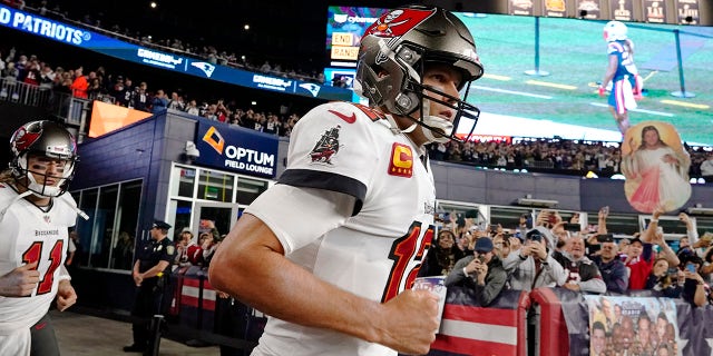 Tampa Bay Buccaneers quarterback Tom Brady runs onto the field of Gillette Stadium before playing the New England Patriots, Oct. 3, 2021, in Foxborough, Massachusetts.