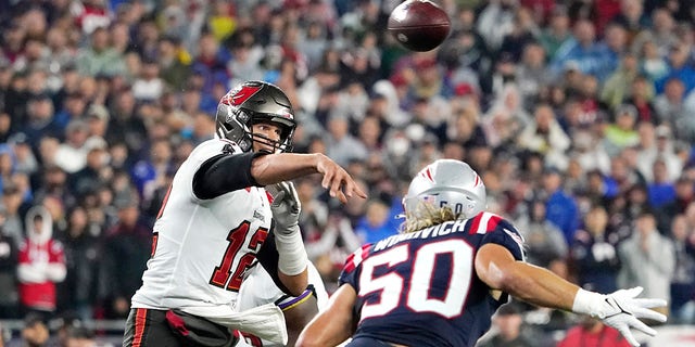 Tampa Bay Buccaneers quarterback Tom Brady (12) throws a pass while pressured by New England Patriots defensive end Chase Winovich (50) during the first half of an NFL football game, Sunday, Oct. 3, 2021, in Foxborough, Mass.