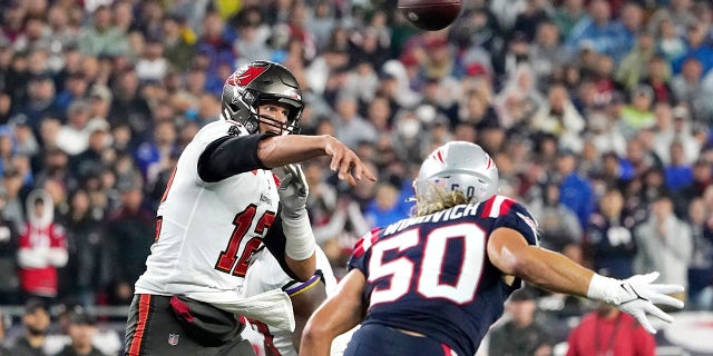 Tampa Bay Buccaneers quarterback Tom Brady (12) throws a pass while pressured by New England Patriots defensive end Chase Winovich (50) during the first half of an NFL football game, Sunday, Oct. 3, 2021, in Foxborough, Mass.