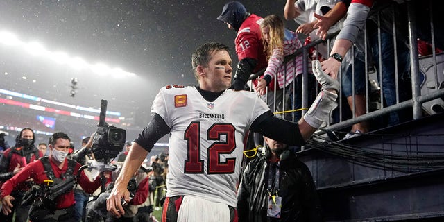 Fans of Tampa Bay Buccaneers, Tom Brady (12), are congratulated by fans after defeating the New England Patriots 19-17 in an NFL football game, Sunday, October 3, 2021, in Foxborough, Mass.