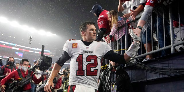 O quarterback do Tampa Bay Buccaneers, Tom Brady (12), é parabenizado pelos fãs após derrotar o New England Patriots 19-17 em um jogo de futebol americano da NFL no domingo, 3 de outubro de 2021 em Foxborough, Massachusetts.