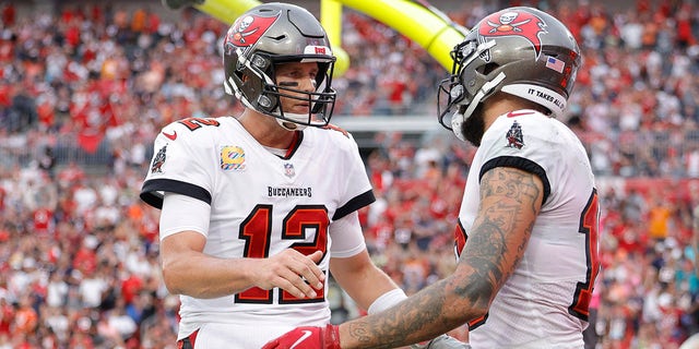 Tom Brady (12) and Mike Evans of the Tampa Bay Buccaneers celebrate after scoring a touchdown in the second quarter against the Chicago Bears in the game at Raymond James Stadium on Oct. 24, 2021, in Tampa, Florida.