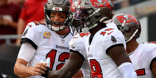Tom Brady (12) of the Tampa Bay Buccaneers celebrates with teammates after scoring a touchdown in the first quarter against the Chicago Bears in the game at Raymond James Stadium Oct. 24, 2021 in Tampa, Fla.