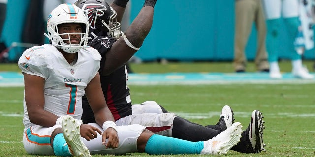 Miami Dolphins quarterback Tua Tagovailoa (1) and Atlanta Falcons defensive tackle Grady Jarrett (97) react after a pass thrown by Tagovailoa was intercepted during the second half Sunday, Oct. 24, 2021, in Miami Gardens, Fla.