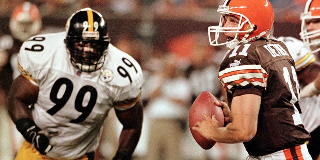 Cleveland Browns quarterback Ty Detmer looks for an open receiver as Pittsburgh Steelers Levon Kirkland closes in during the second quarter on Sept. 12, 1999, at Cleveland Browns Stadium in Ohio. The Browns lost to the Steelers 43-0.