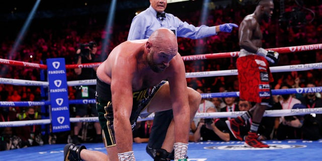 Tyson Fury, of England, gets up after he was knocked down by Deontay Wilder in a heavyweight championship boxing match Saturday, Oct. 9, 2021, in Las Vegas.